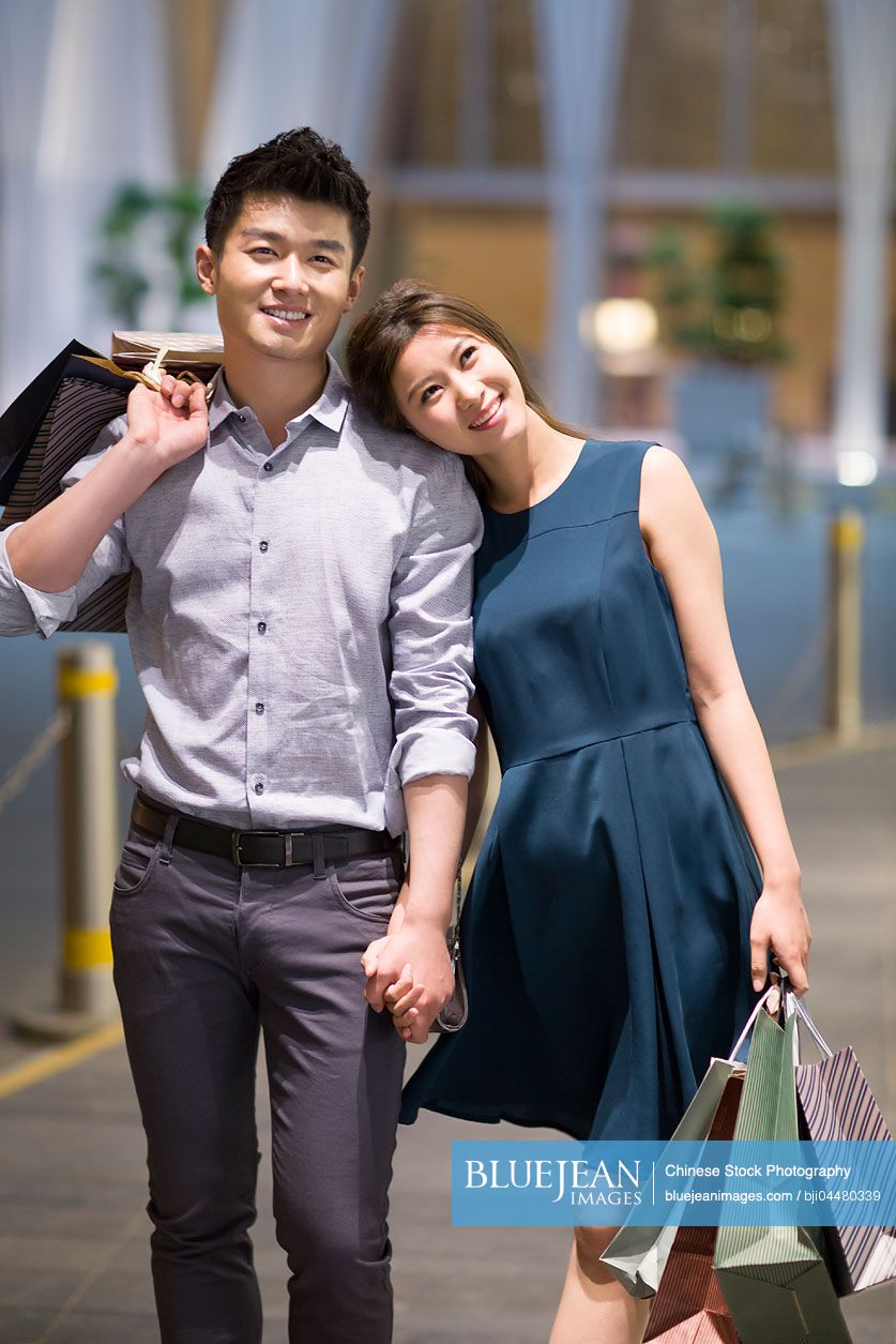 Happy young Chinese couple shopping