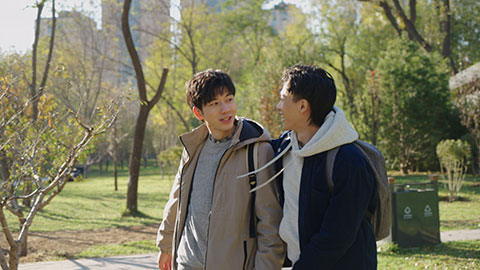 Happy Chinese college boys walking and talking