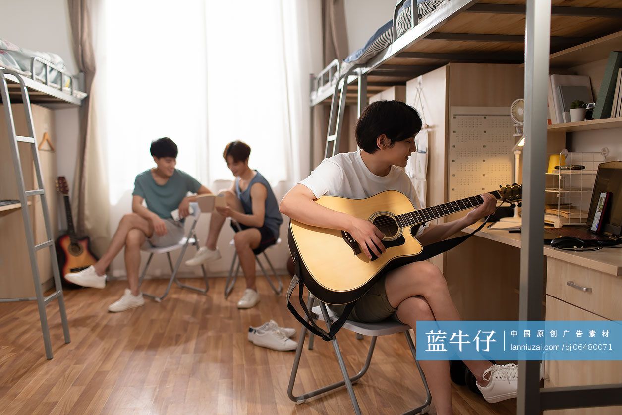 年轻大学生在宿舍弹吉他
