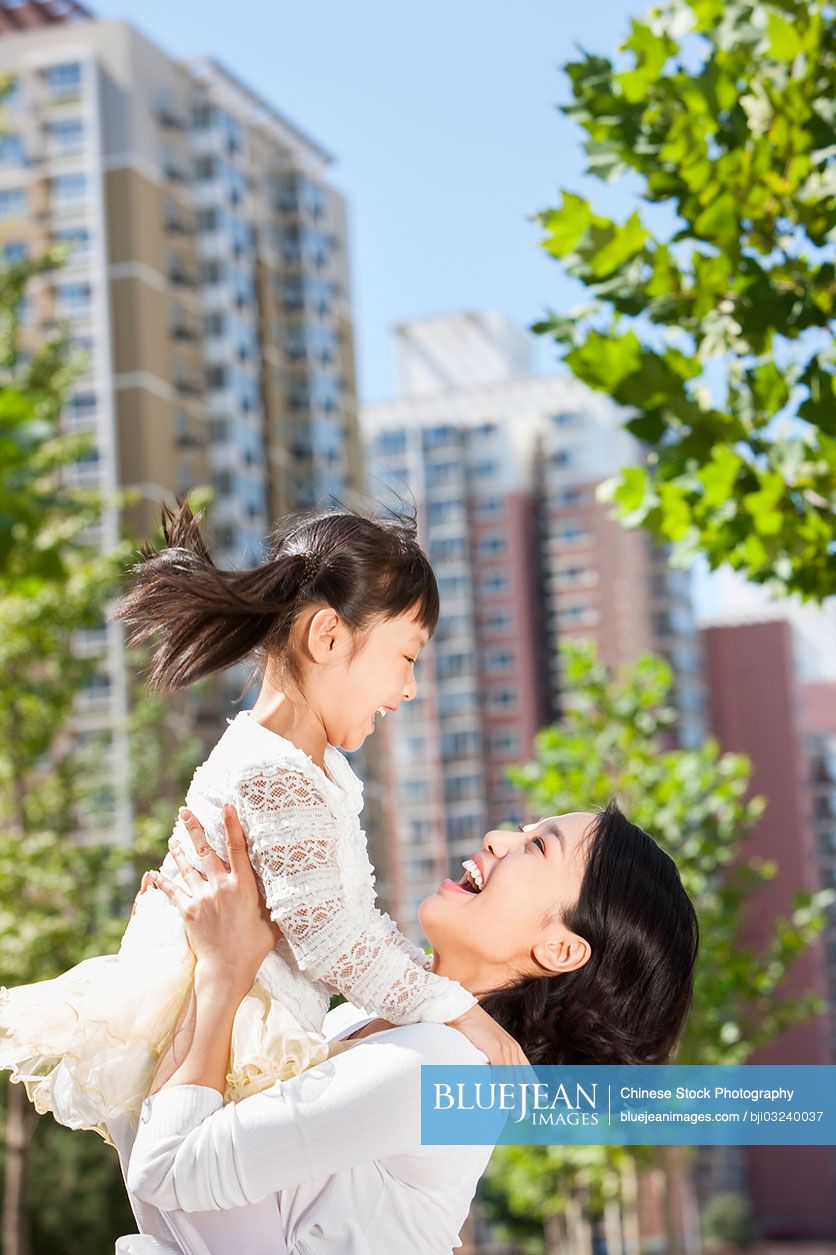 Chinese mother holding daughter in arms