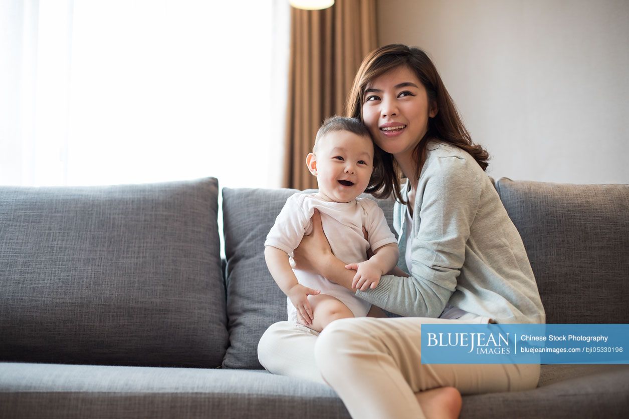 Happy Chinese mother and cute baby at home