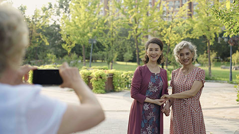 Senior Chinese friends taking pictures in park,4K