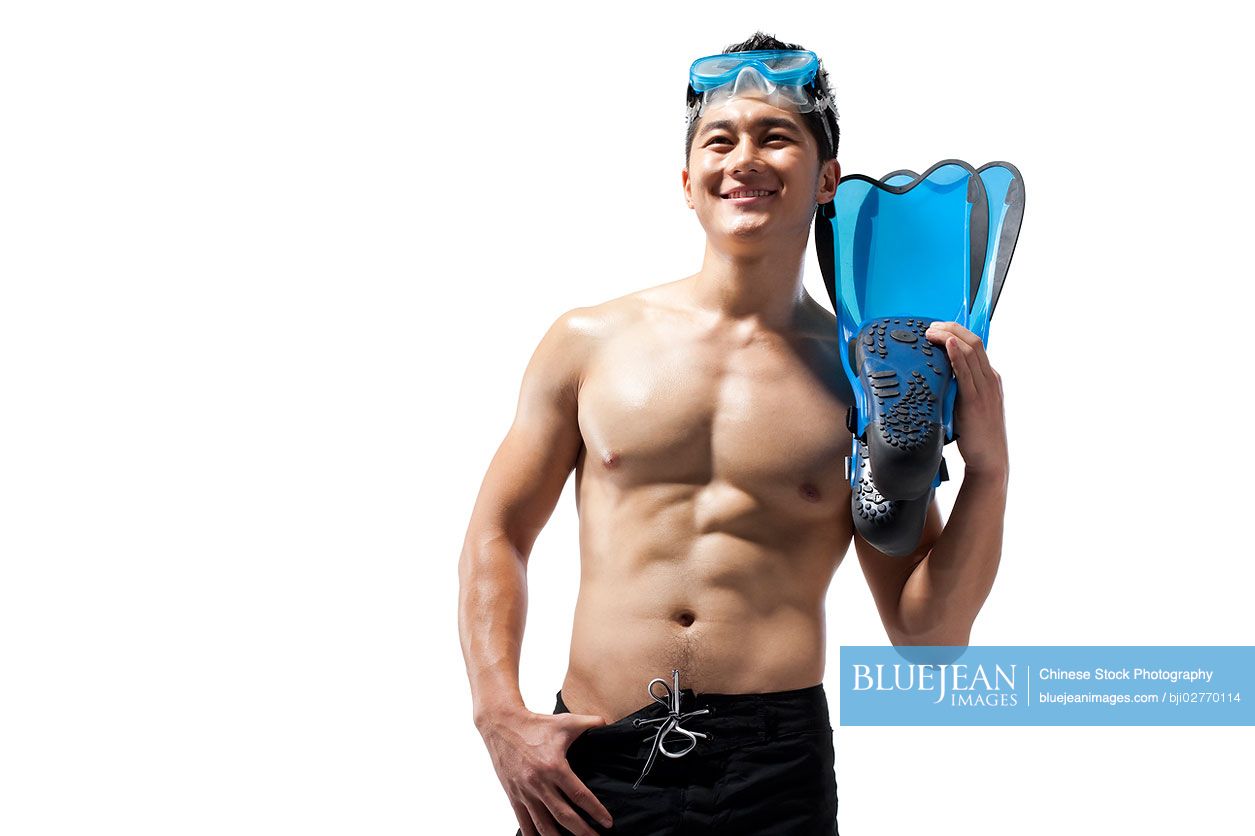 Shirtless muscular Chinese man holding swimming gear