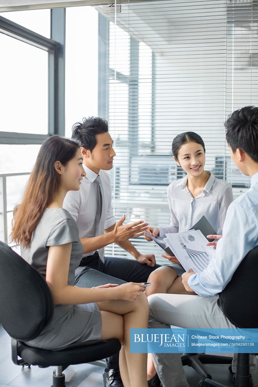 Young Chinese business people talking in meeting