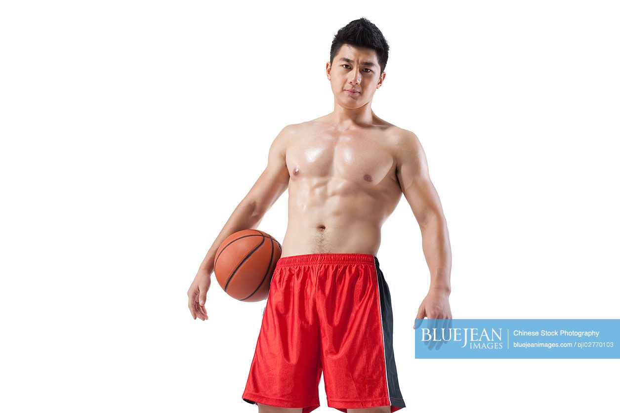 Shirtless muscular Chinese man holding a basketball