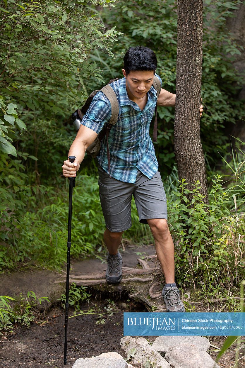 Young Chinese man hiking outdoors