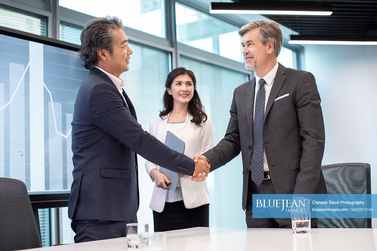 Business people shaking hands in conference room