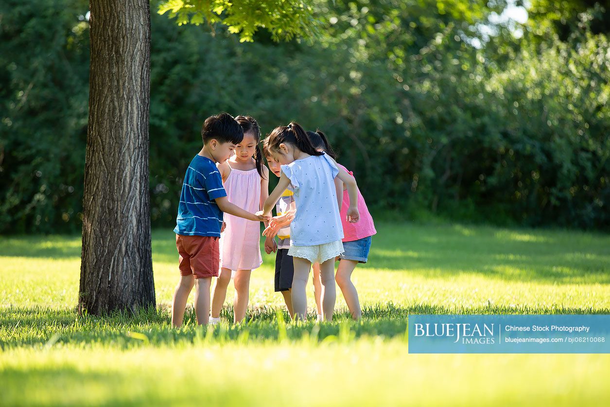 Happy Chinese children playing on meadow