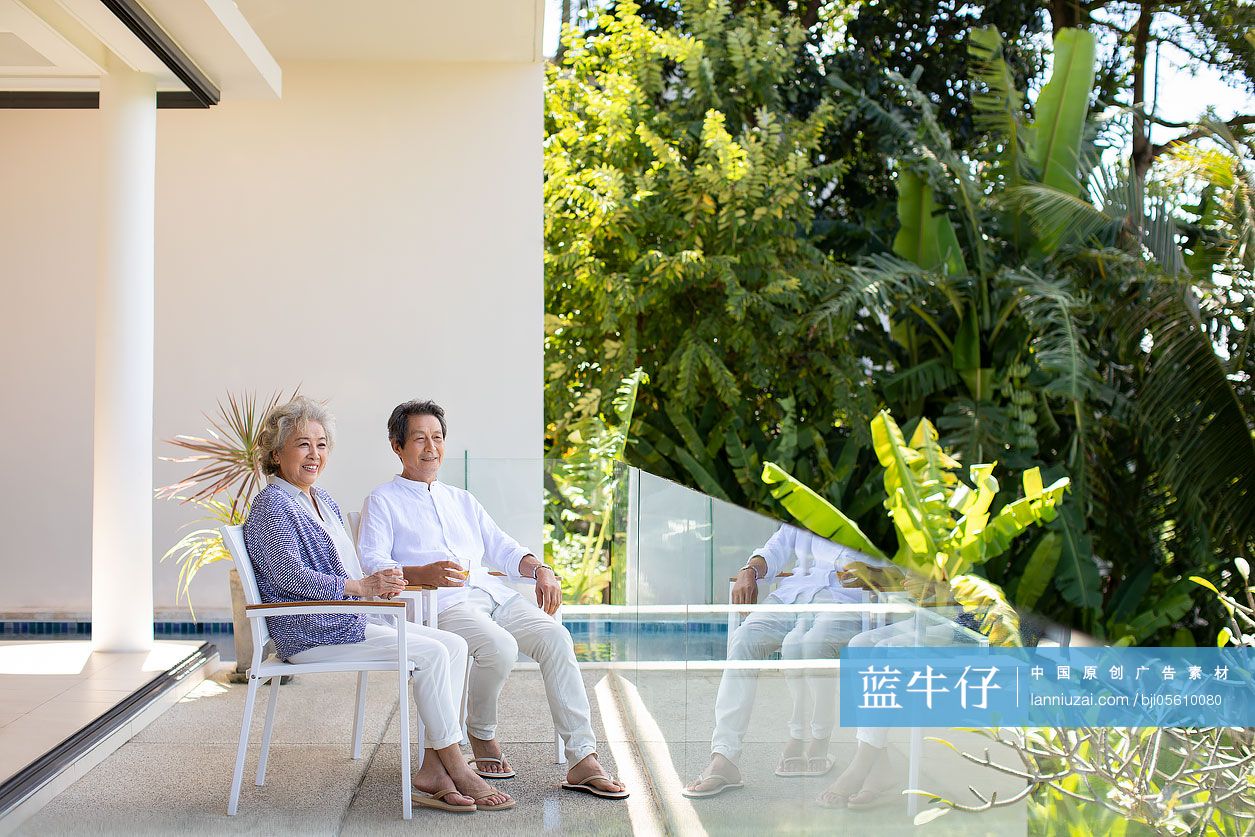 快乐的老年夫妇在阳台喝酒