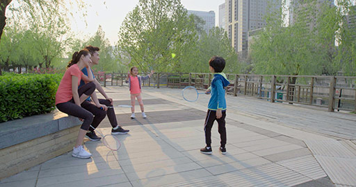 Happy young Chinese family playing badminton in park,4K