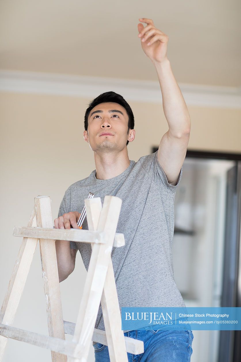 Young Chinese man working on home renovation