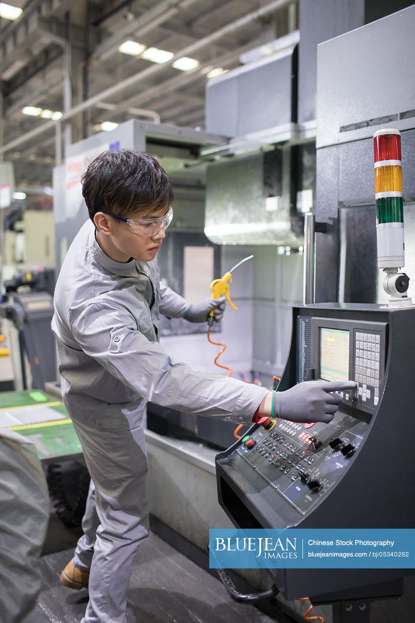 Confident Chinese engineer working in the factory