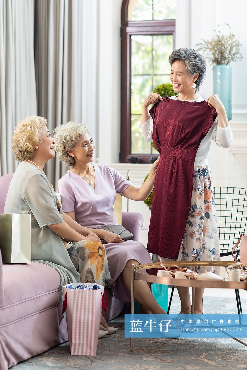 老年女子向朋友展示新买的裙子
