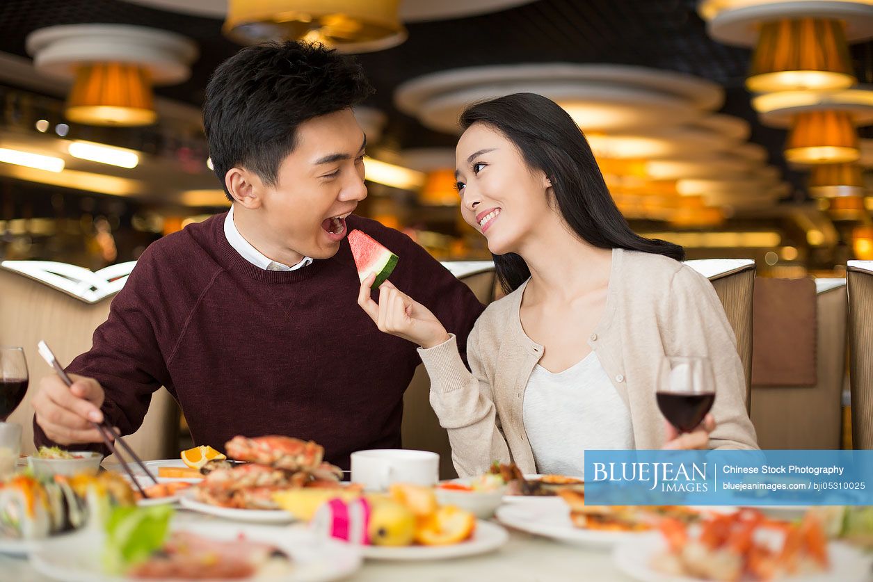 Cheerful young Chinese couple having buffet dinner