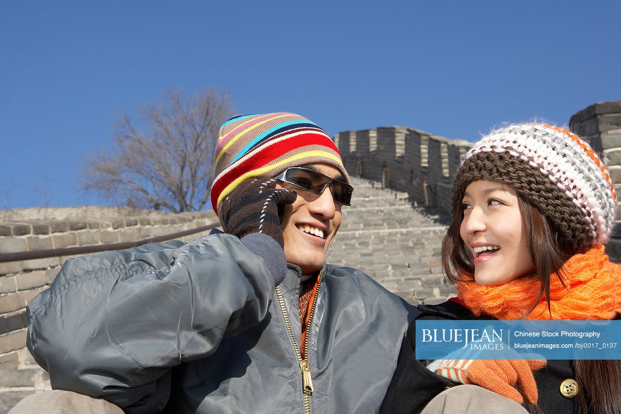 Young Chinese Couple On The Great Wall Of China, Smiling At Each Other