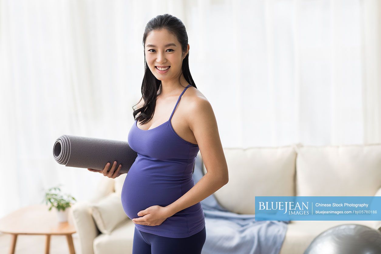 cheerful-chinese-pregnant-woman-with-yoga-mat-high-res-stock-photo-for