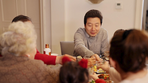 A son gifting his father a fine bottle of spirits to celebrate Chinese New Year