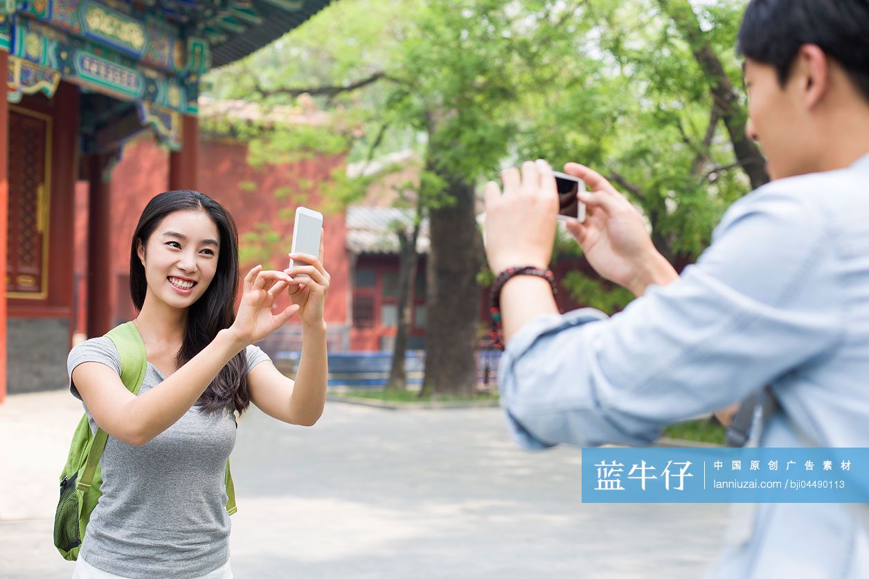 年轻情侣在雍和宫用手机拍照