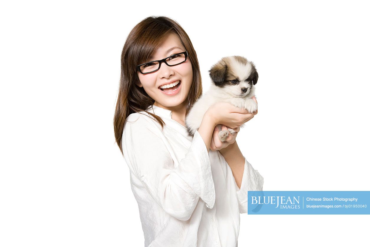 Portrait of young Chinese woman with Shih Tzu puppy