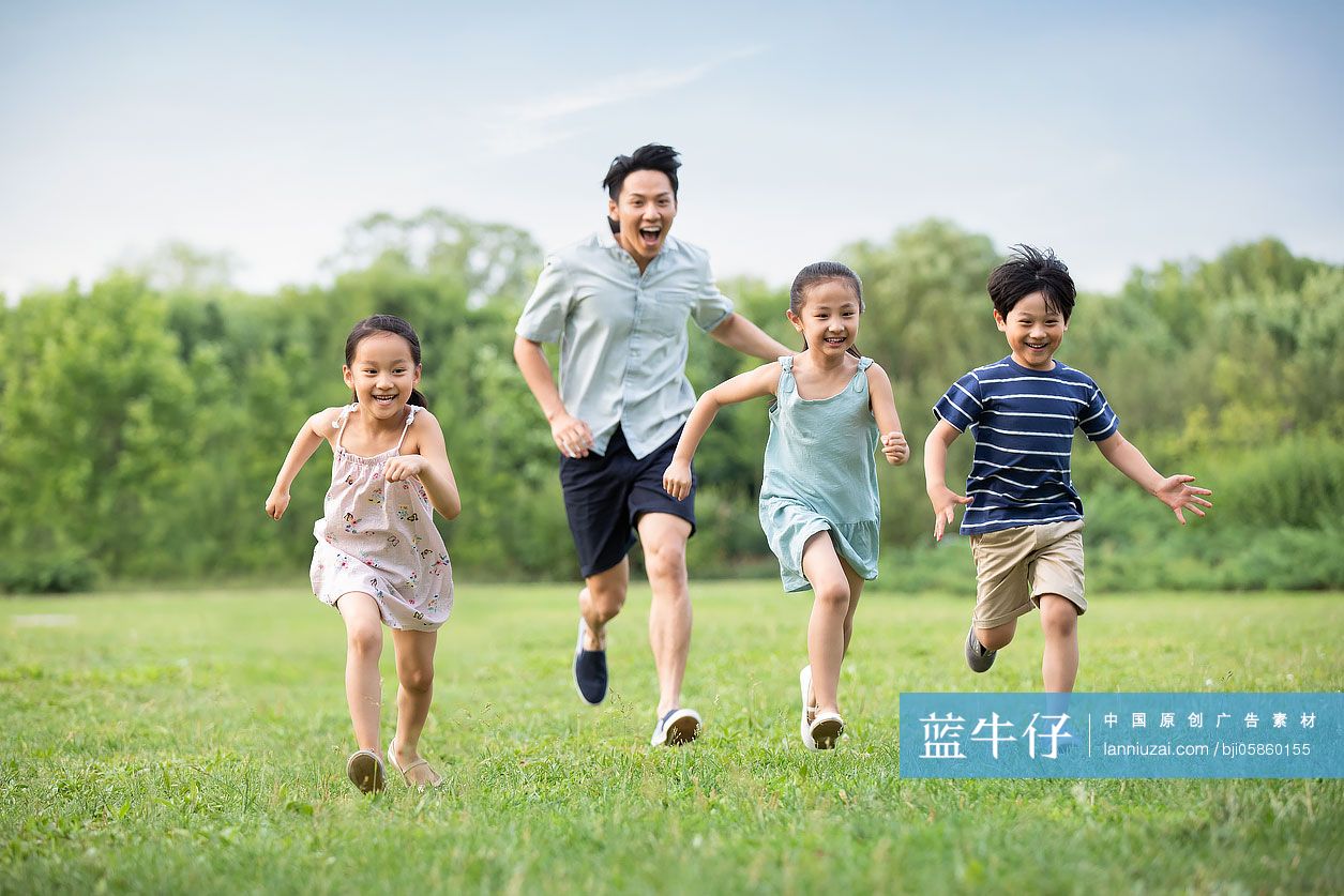 快乐年轻家庭在草地上奔跑