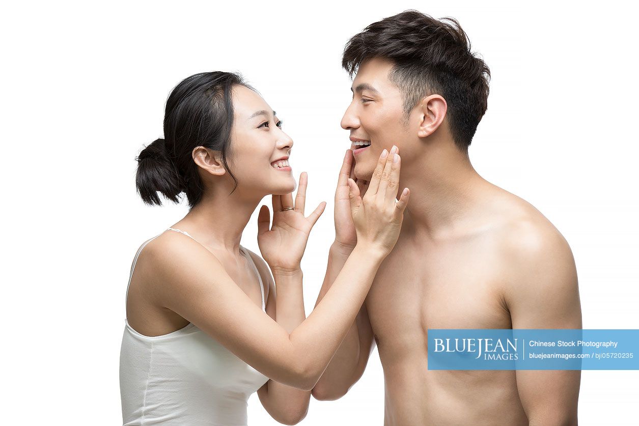 Young Chinese couple applying moisturizer