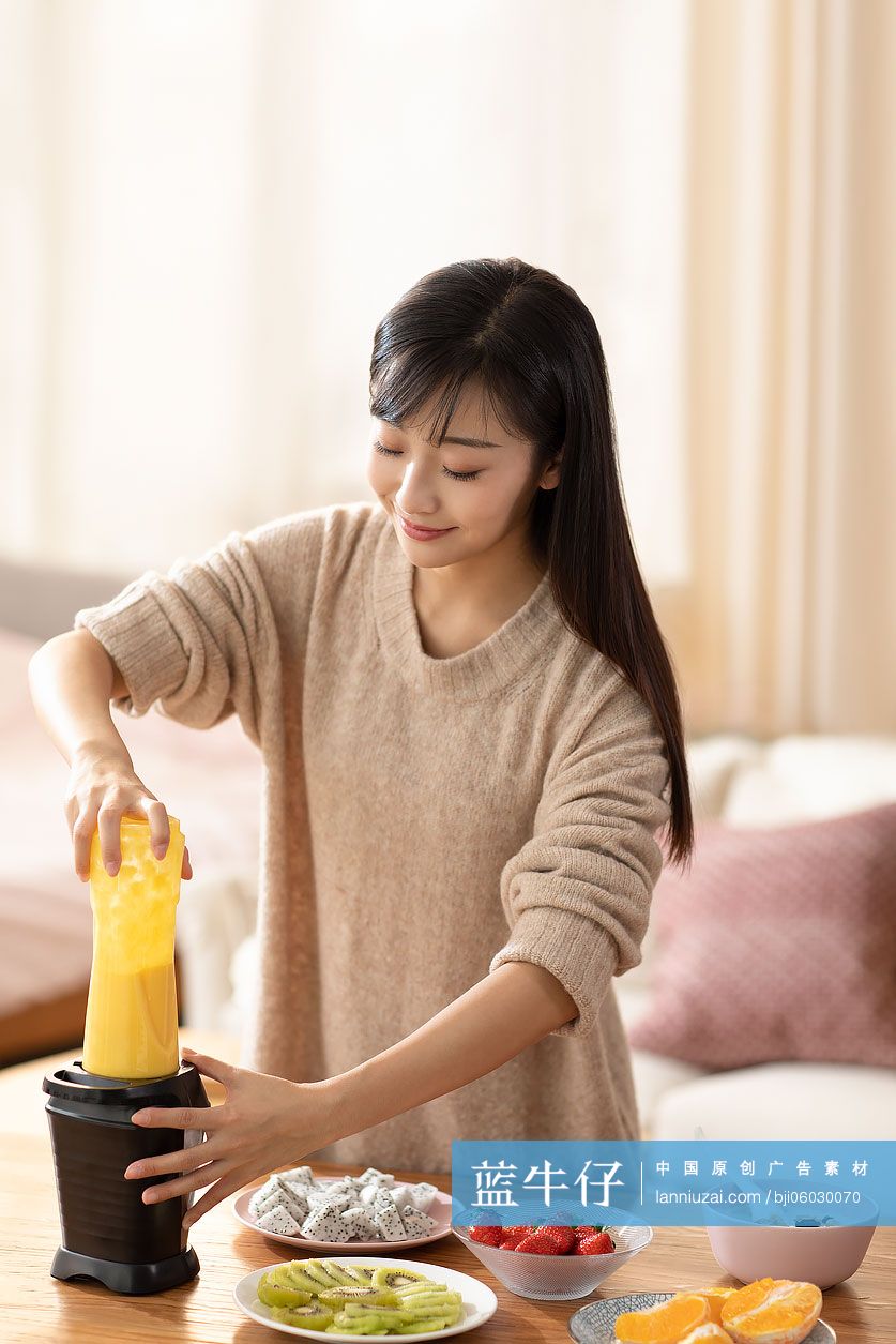 年轻女士在家榨果汁