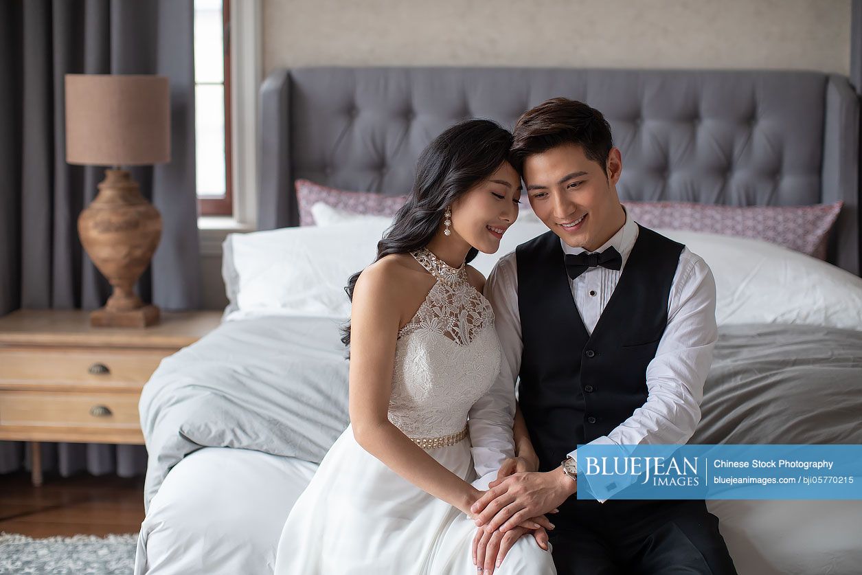Happy young Chinese couple enjoying their love in bedroom