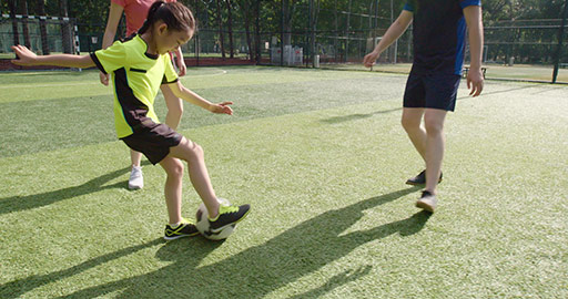 Happy young Chinese family playing football on soccer field,4K