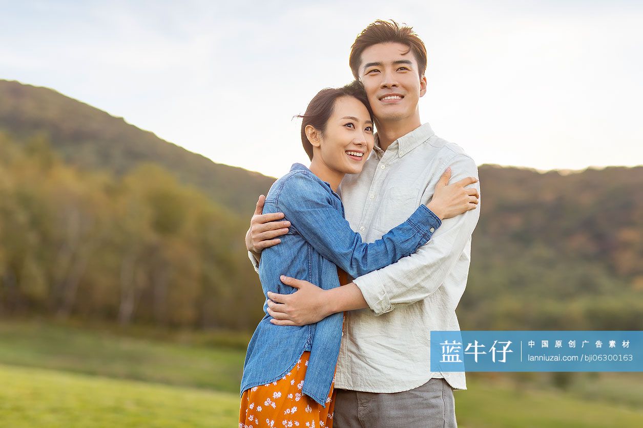 快乐的年轻情侣相拥眺望远方