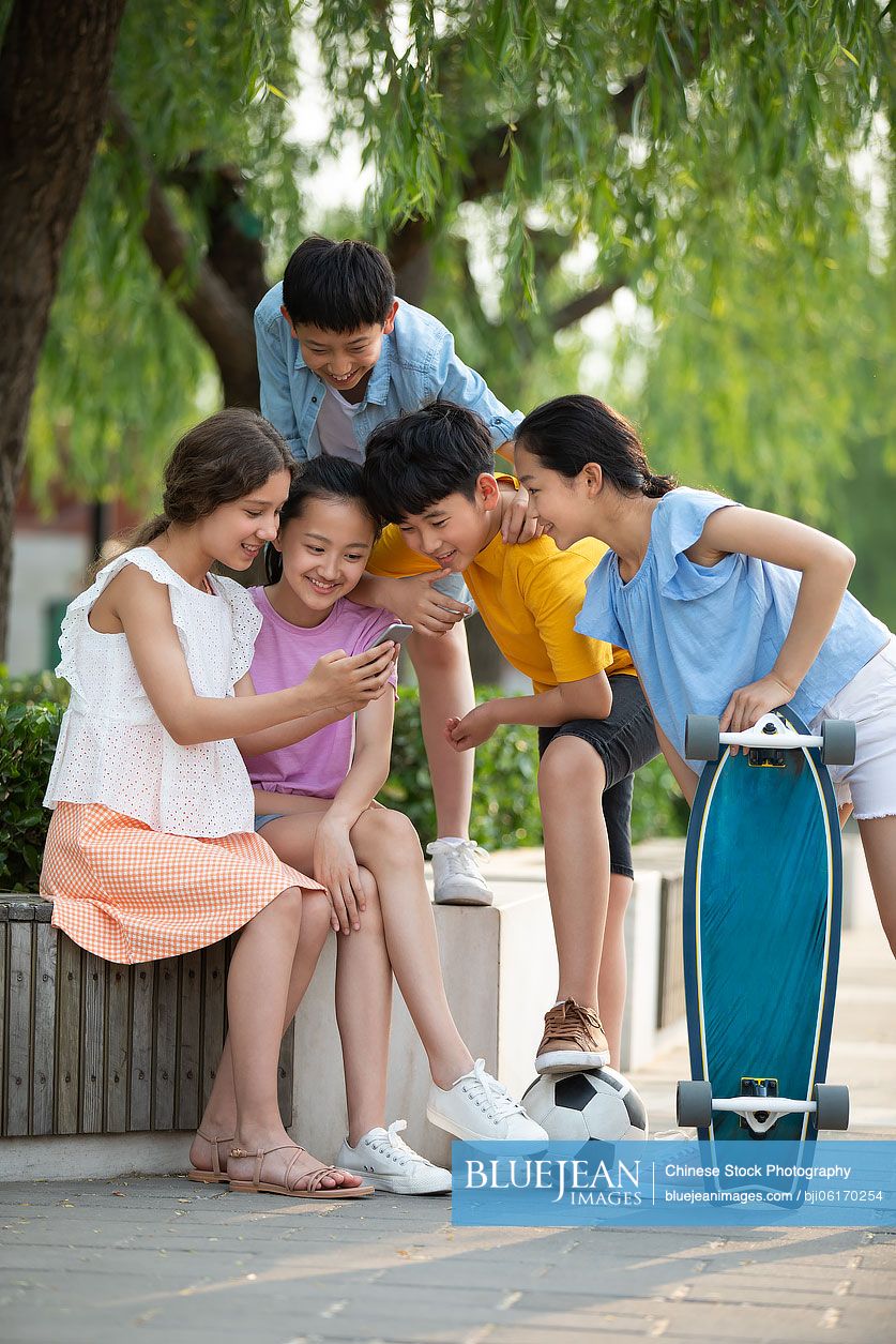 Teenagers using smartphone outdoors
