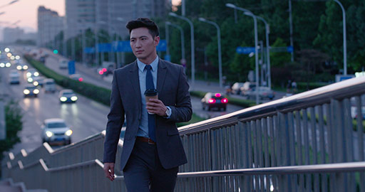 Young Chinese businessman holding a cup of coffee outdoors,4K