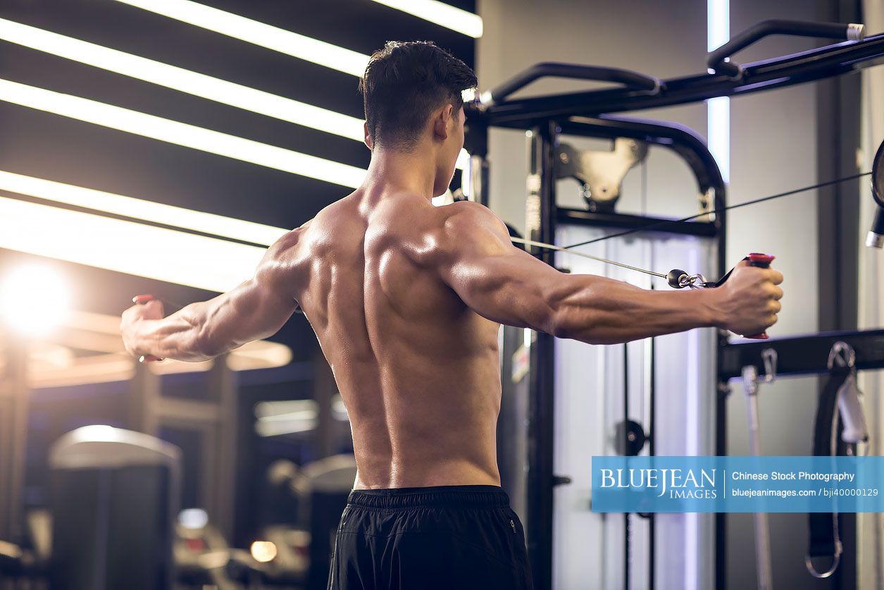 Young Chinese man exercising at gym