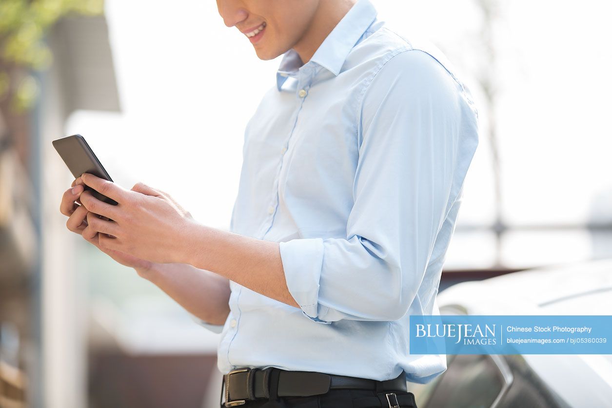 Young Chinese businessman with smart phone