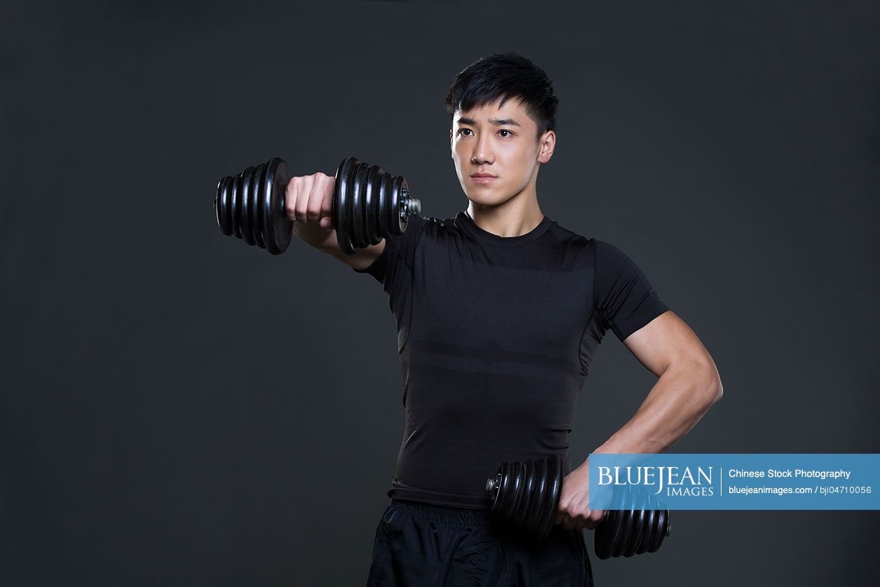 Young Chinese man lifting weights