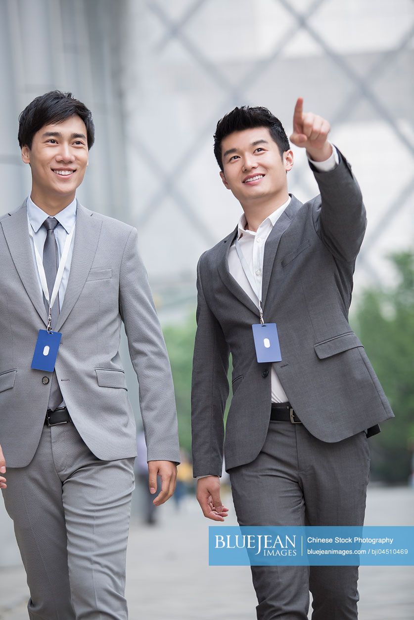 Young Chinese business person talking outdoors
