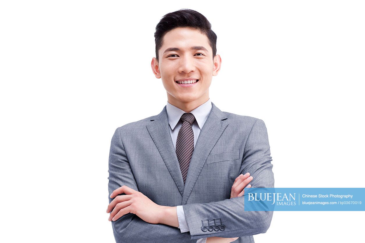 Confident young Chinese businessman arms crossed