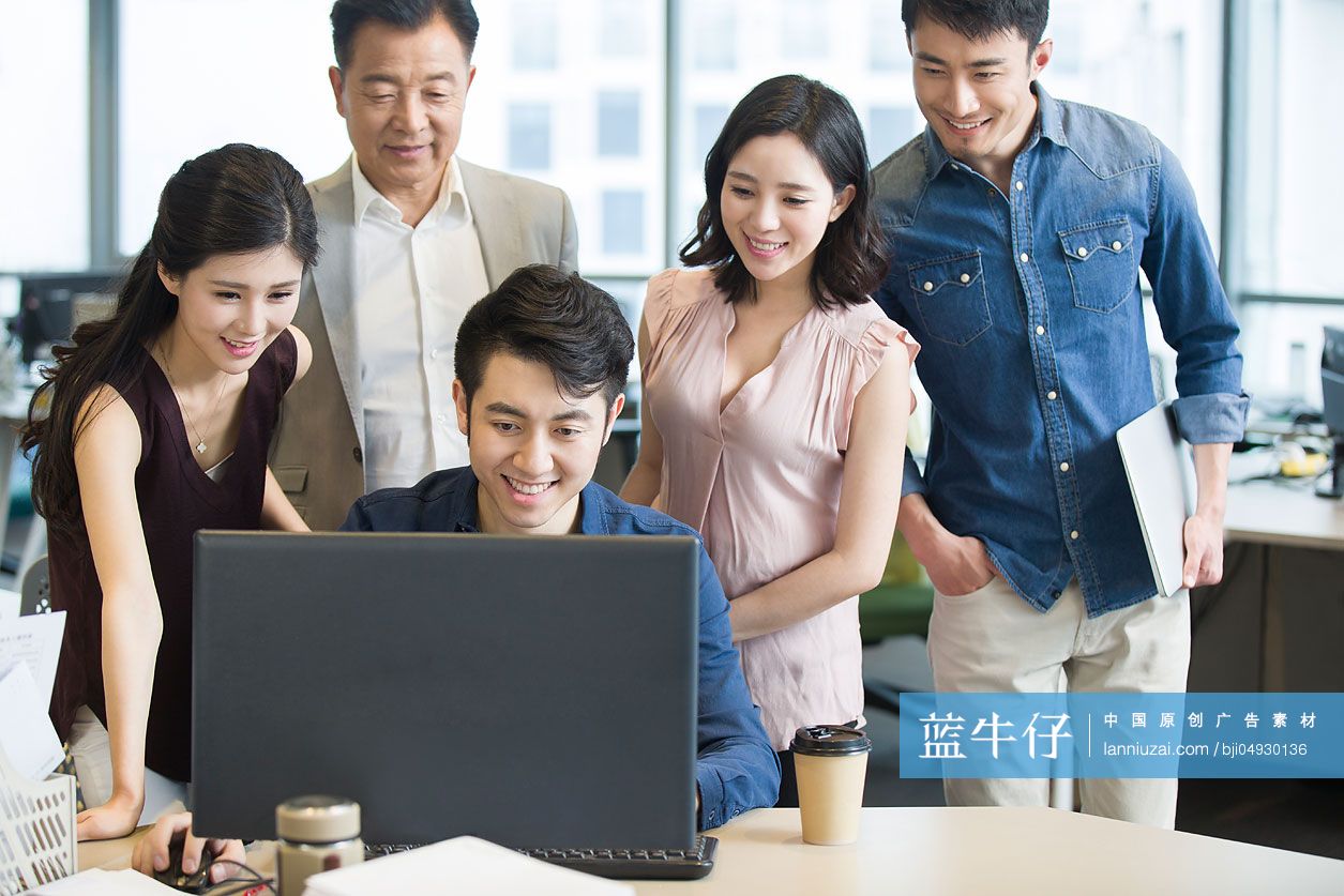 商务人士围着电脑工作