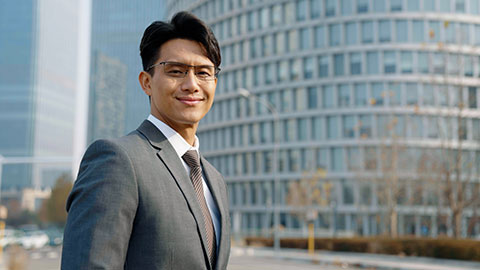 Confident Chinese businessman standing outdoors