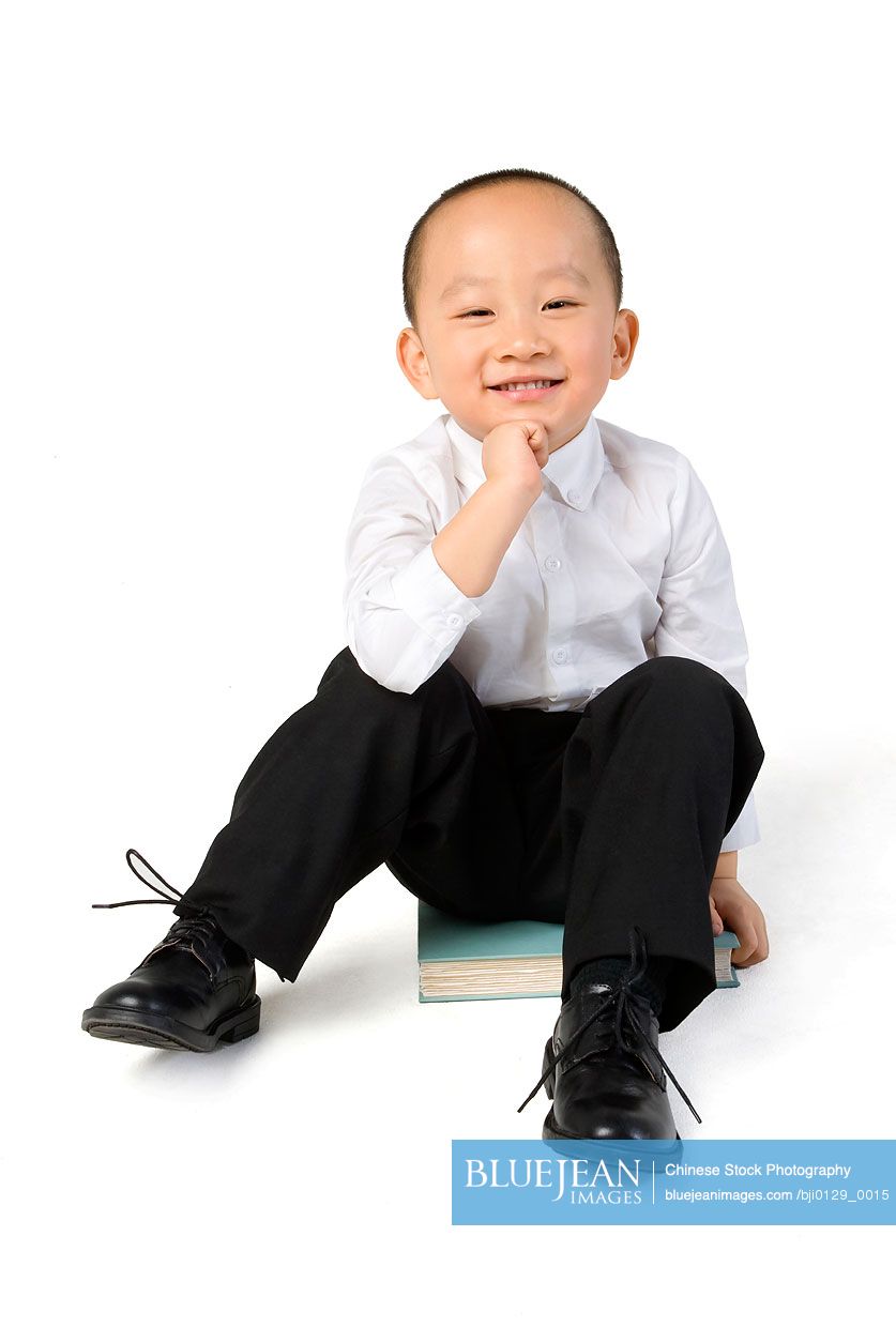 Young Chinese boy sits on some books