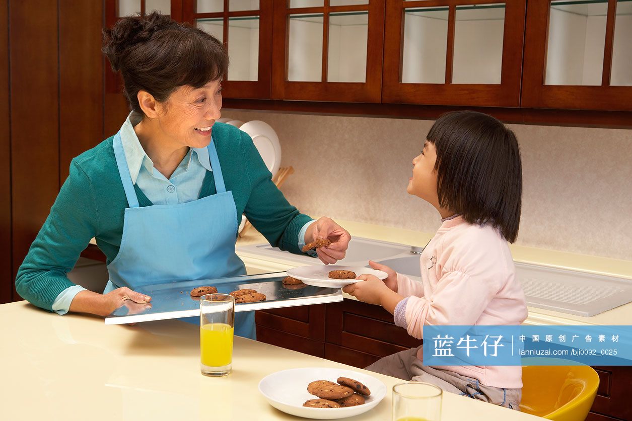 开心的奶奶和孙子孙女在沙发上看书-蓝牛仔影像-中国原创广告影像素材