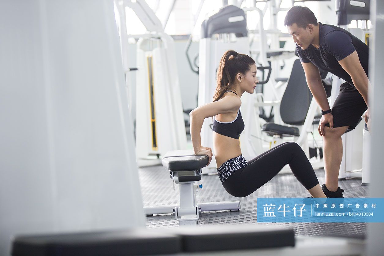 年轻女子在教练的指导下健身
