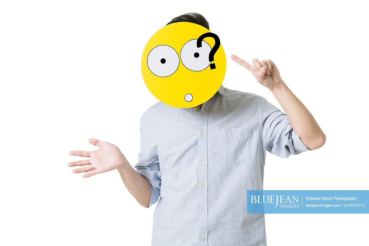 Young Chinese man with a confused emoticon face in front of his face