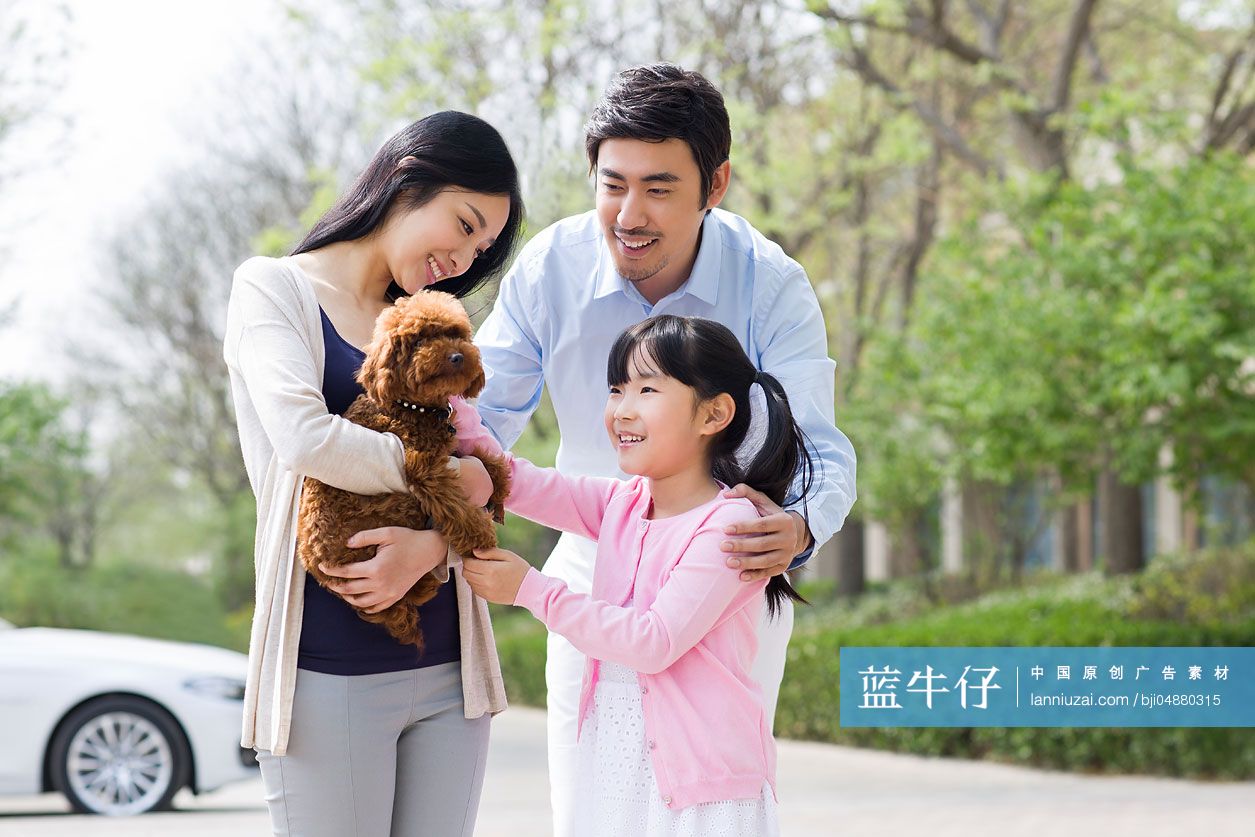 年轻家庭和宠物狗玩耍