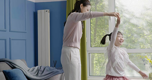Mom and daughter dancing casually at home