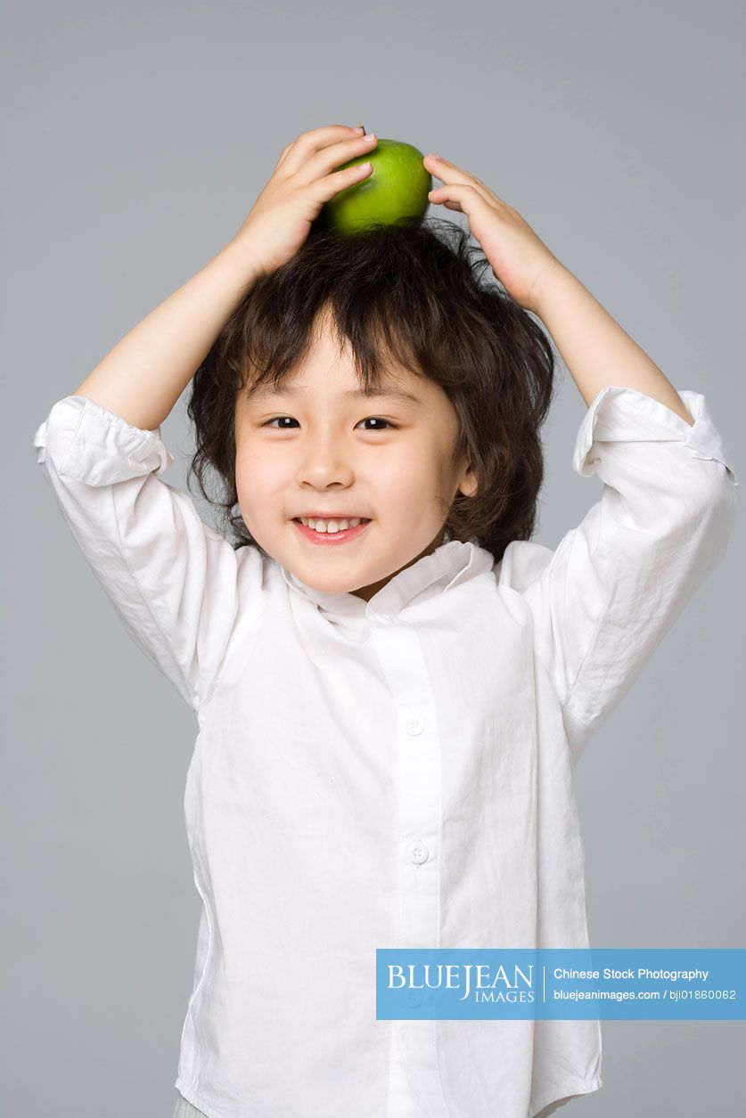 Chinese boy balancing an apple on his head
