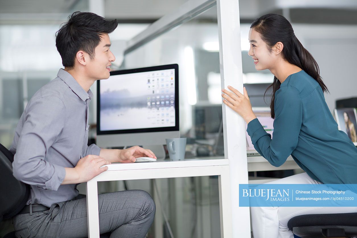 Young Chinese business person talking in office