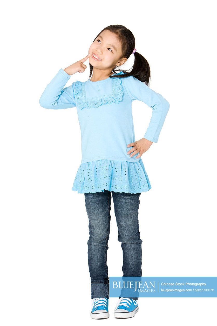 Young Chinese girl happily thinking with hands on hip