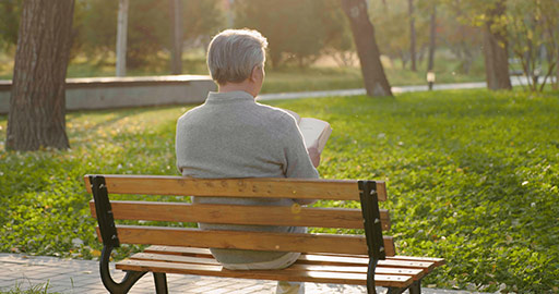 Senior Chinese man reading book in the park,4K