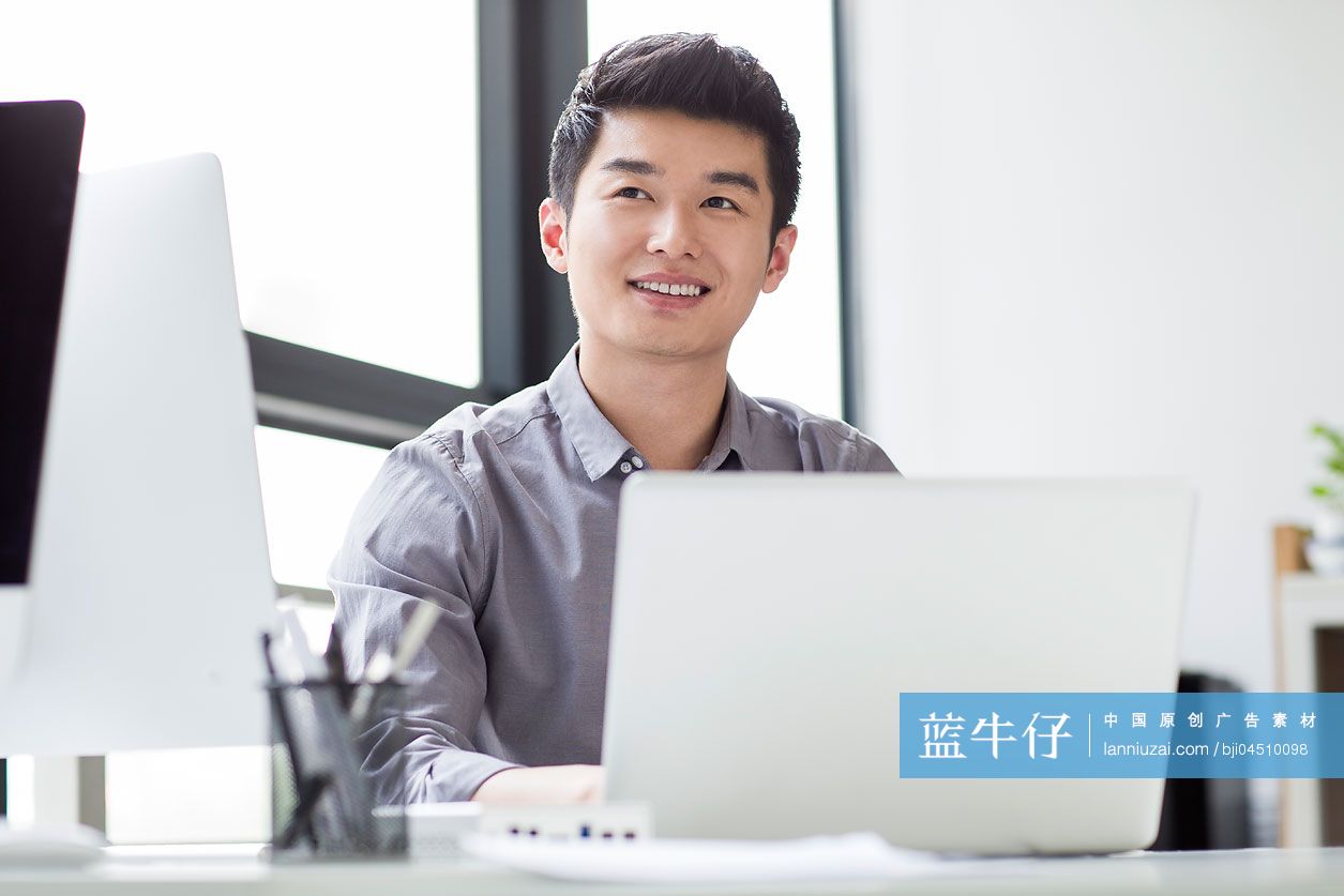 年轻商务男士在办公室使用笔记本电脑