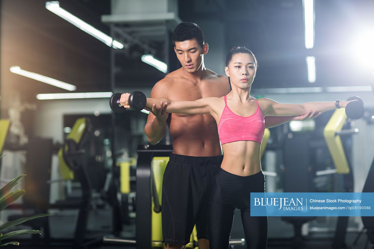 Young Chinese woman working with trainer at gym-High-res stock photo ...